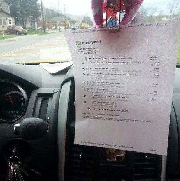 A Mapquest map printed out and hanging on the dashboard mirror