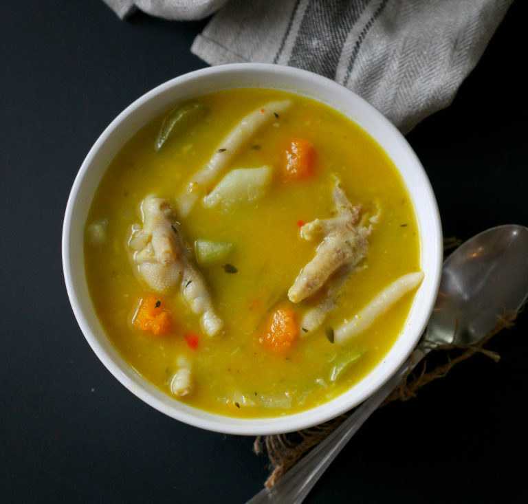 A traditional Jamaican soup made with chicken feet, carrots, yam, boiled du...
