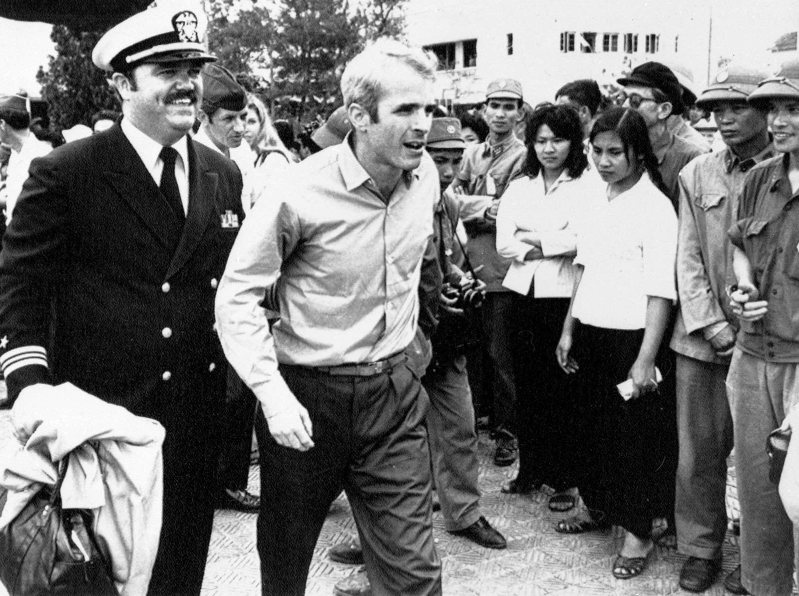 McCain is escorted by Lt. Cmdr. (later captain) Jay Coupe Jr., public relations officer, on March 14, 1973, to Hanoi&#x27;s Gia Lam Airport after the POW was released.