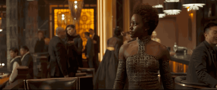 T'Challa, Nakia, and Okoye, try not to draw too much attention to themselves so that they don't blow their cover. Next, we see Ulysses and Everett chatting on the floor below our trio, who suspect something is amiss.