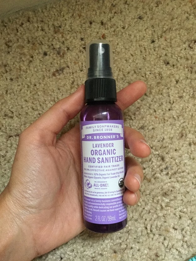 A hand holding the lavender spray bottle