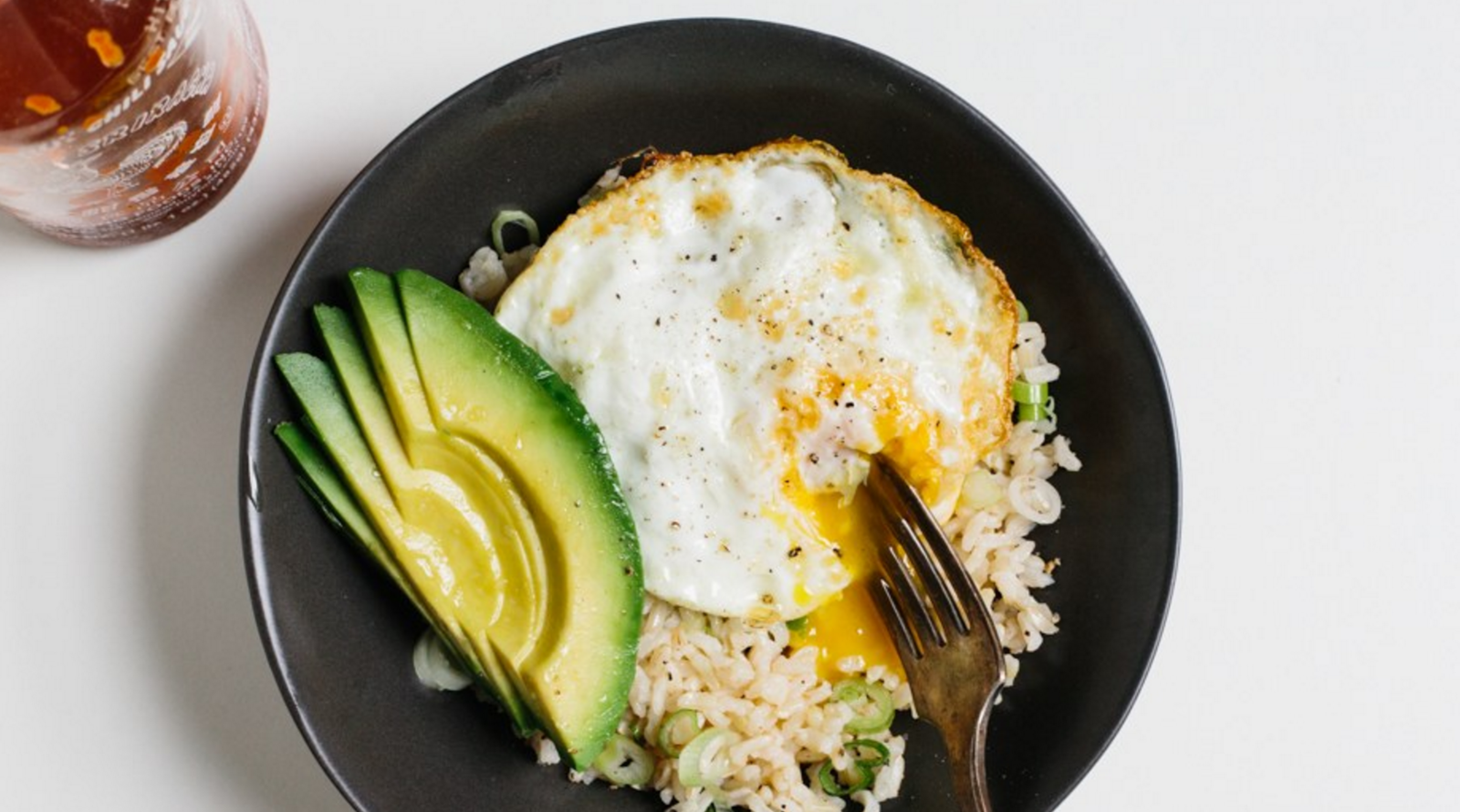 Rice, fried egg, and avocado in a bowl
