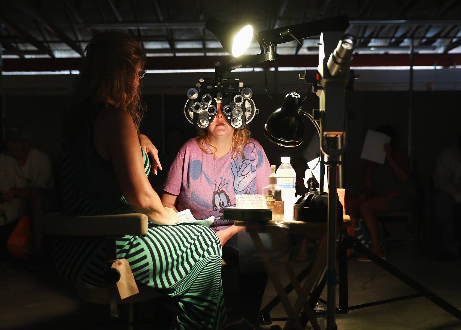 A volunteer checks a patient's vision at the RAM clinic in Wise on July 21.