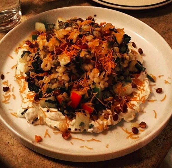 A signature dish at Ruffian, the Lentil Salad is made with fresh, seasonal ingredients like nectarine, apple, ginger, and chili, and served on a bed of spiced yogurt.