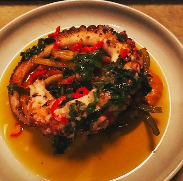 A big, tender tentacle of octopus that is grilled and charred to perfection is complemented by a medley of artichoke, garlic scapes, beans, and anchovy on romesco sauce.