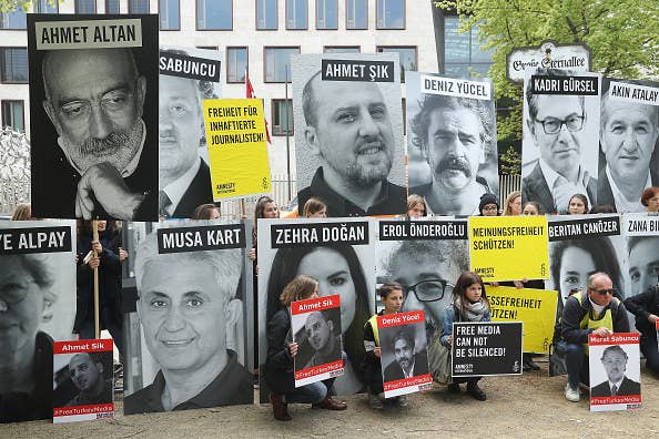 Supporters hold photos of jailed journalists in front of the Turkish Embassy in Berlin.