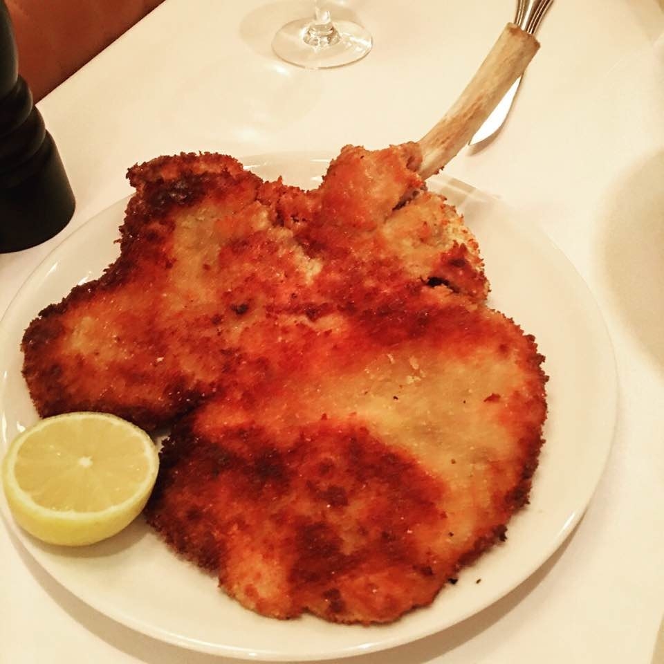 Don't be alarmed by the size of this veal chop! The Costoletta di vitello alla milanese con insalata e pomodorini -- as the name suggests -- is a chunk of breaded and pan-fried milanese veal chop. The dish is served with a side of green salads and diced tomatoes, and a bucket of fries.