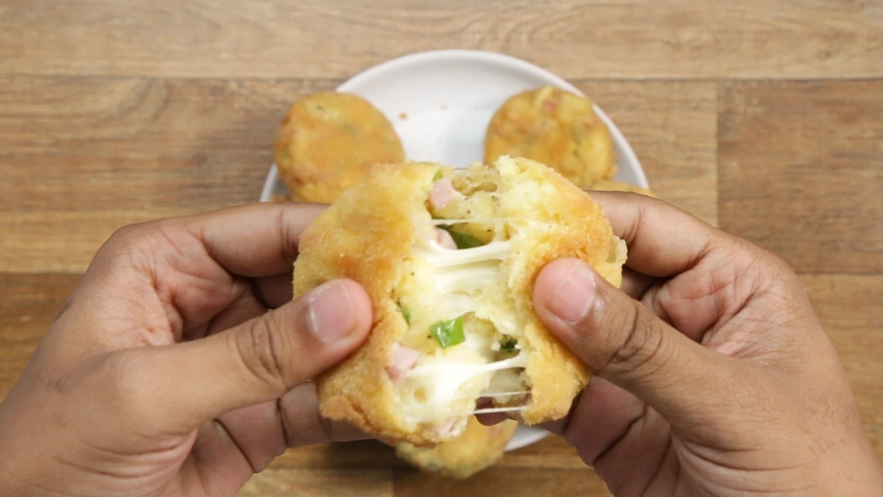 Rendimento: 6-8Você vai precisar de:4 batatas médias descascadas e cortadas em pedaços médios2 colheres de chá de sal175g de presunto cortado em pedaços pequenos100g de queijo muçarela cortado em pedaços pequenos⅓ de xícara de cebolinha picada 1 colher de chá de pimenta1 colher de sopa de leite1 xícara de farinha de trigo4 ovos batidos2 xícaras de farinha de rosca (ou farinha para empanar)Óleo para fritarModo de preparo:1. Aqueça água em uma panela até a fervura e adicione as batatas, 1 colher de chá de sal e mexa.2. Cubra e ferva por 10-15 minutos, até que um garfo possa furar as batatas com facilidade.3. Seque as batatas em uma toalha, permitindo que resfriem para remover o excesso de umidade, então transfira para um refratário grande.4. Amasse as batatas até que não haja nenhum pedaço grande.5. Adicione presunto, queijo, cebolinha, e outra colher de chá de sal, pimenta e leite.6. Mexa até que esteja tudo bem incorporado.7. Modele a mistura de batata em discos de 5 cm.8. Separe a farinha, ovos e farinha de pão em refratários diferentes.9. Passe os croquetes na farinha, retirando o excesso, depois passe nos ovos e depois cubra-os de forma homogênea com a farinha de pão.10. Aqueça óleo em uma panela a 180°C.11. Frite 2-3 croquetes por vez até ficarem dourados, depois retire o excesso de óleo em um prato forrado com papel toalha. 12. Esfrie, depois sirva com o repolho e molho.13. Bom apetite!