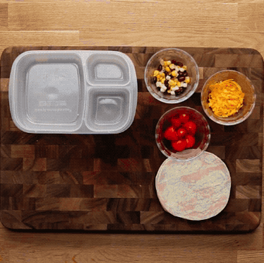 BUILD-YOUR-OWN TACOSServes 1INGREDIENTS2 mini tortillas2 tablespoons black beans, drained2 tablespoons frozen corn, thawed¼ cup shredded cheddar cheese¼ cup grape tomatoes, cut in half1 apple, sliced (optional)Carrot sticks (optional)Crackers (optional)Roll tortillas and place in lunch box. Combine black beans and corn and place in a cupcake liner in the lunch box. Place cheddar cheese and tomatoes in two more cupcake liners and put in the lunch box. Serve with a sliced apple and crackers.