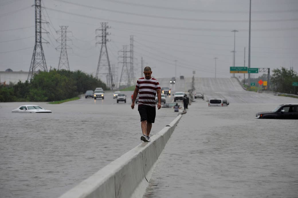 Un motociclista varado escapa del agua en la Interestatal 225 en Houston luego de que el huracán Harvey inundara masivamente con lluvias la costa del Golfo de Texas, 27 de agosto de 2017.