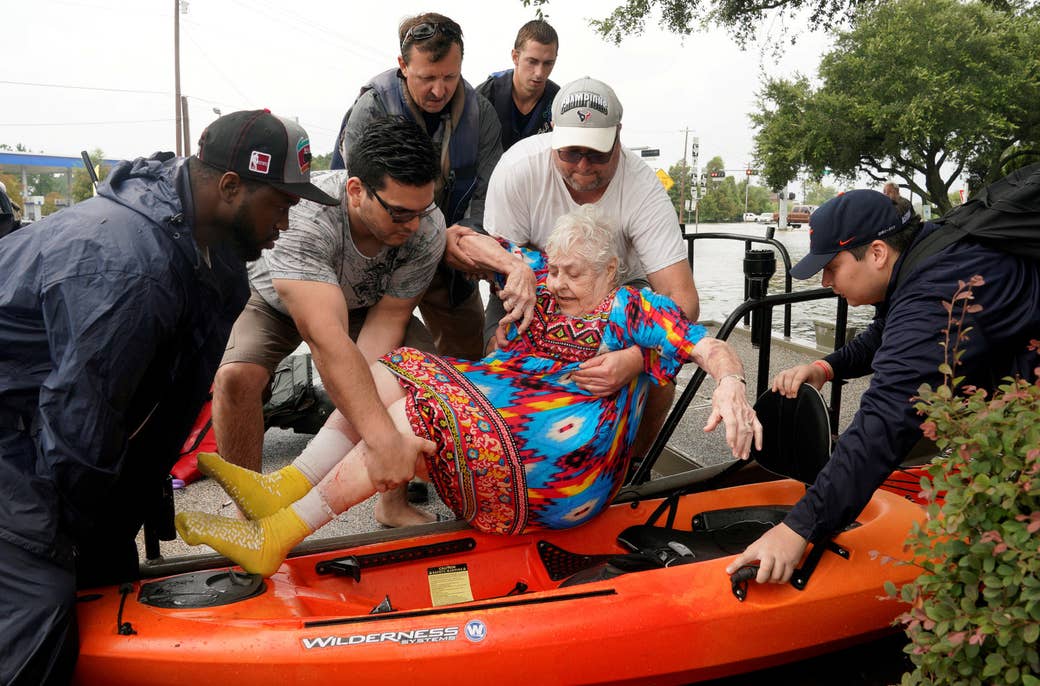 Sterling Broughton es pasado de un bote de rescate a un kayak luego de que las aguas del huracán Harvey se elevaran en Dickenson, Texas, 27 de agosto de 2017.