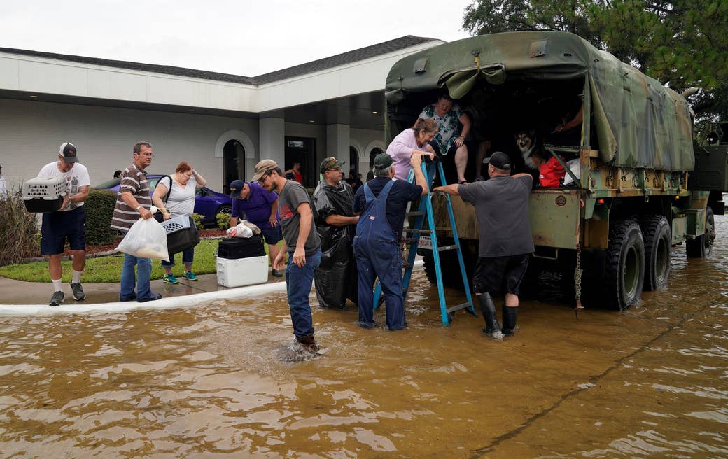 Voluntarios suben a personas a un camión militar antiguo de colección para evacuarlas de la inundación causada por el huracán Harvey en Dickinson, Texas, el 27 de agosto de 2017. REUTERS/Rick Wilking