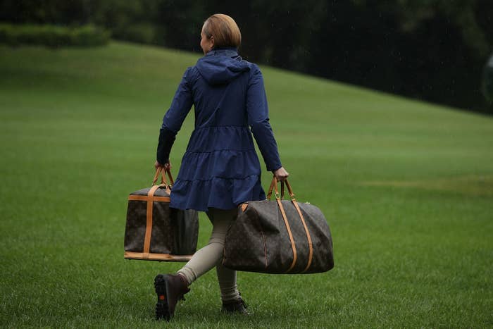 A White House aide carries Louis Vuitton bags prior to United