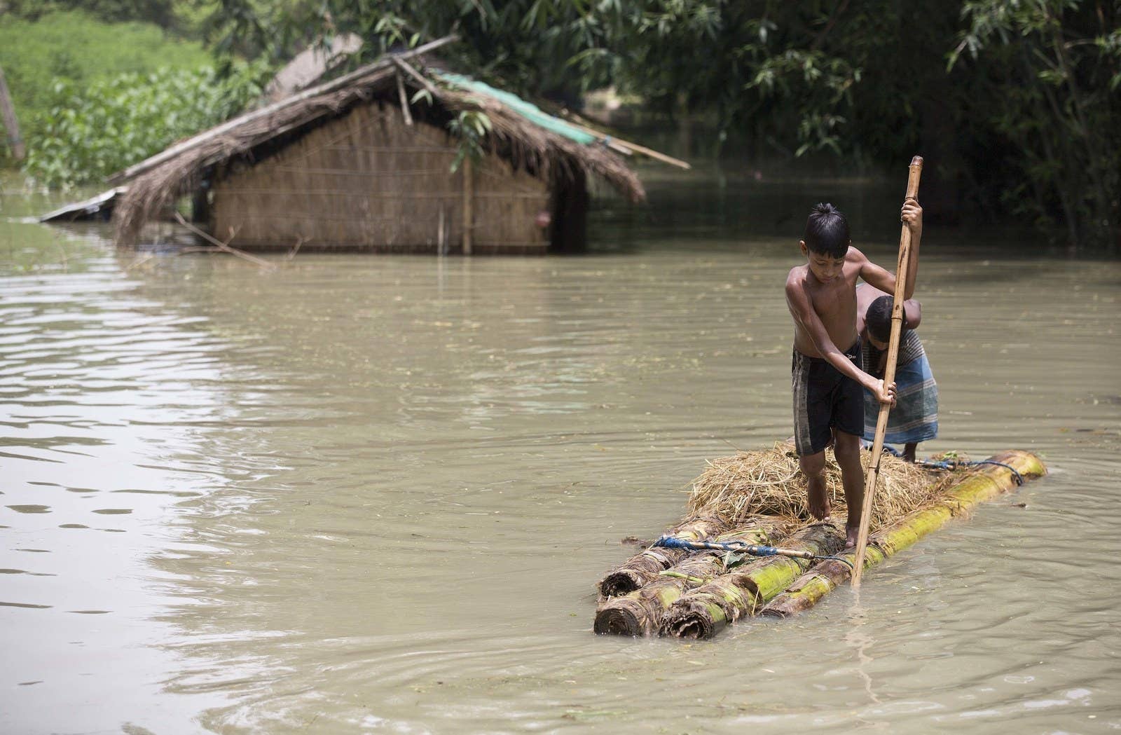 Deux garçons se tiennent debout sur un radeau de fortune au Assam, dans l'est de l'Inde. Au moins 850 personnes ont été tuées dans les États touchés par les inondations à travers le pays.