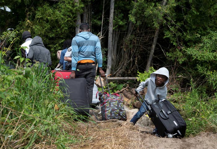 A family claiming to be from Haiti drags their luggage over the US-Canada border on Aug. 3, 2017.