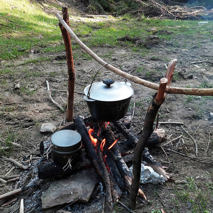 Campfire with a cooking pot featuring campfire, cooking, and fire