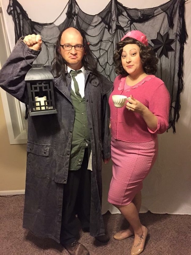 One person in a trench coat holding a lantern and one person wearing all pink