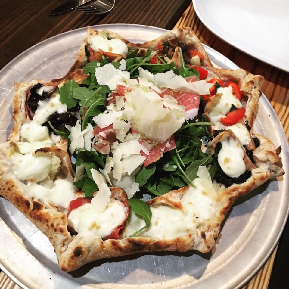 A signature dish at Mandolino, the Stella Pizza features eight different flavors with arugula, prosciutto, and shaved parmesan in the middle. The flavors include everything from San Marzano tomatoes, chantarelle mushrooms, and Italian sweet sausage to Fior di latte mozzarella, broccoli di rabe, and anchovies.