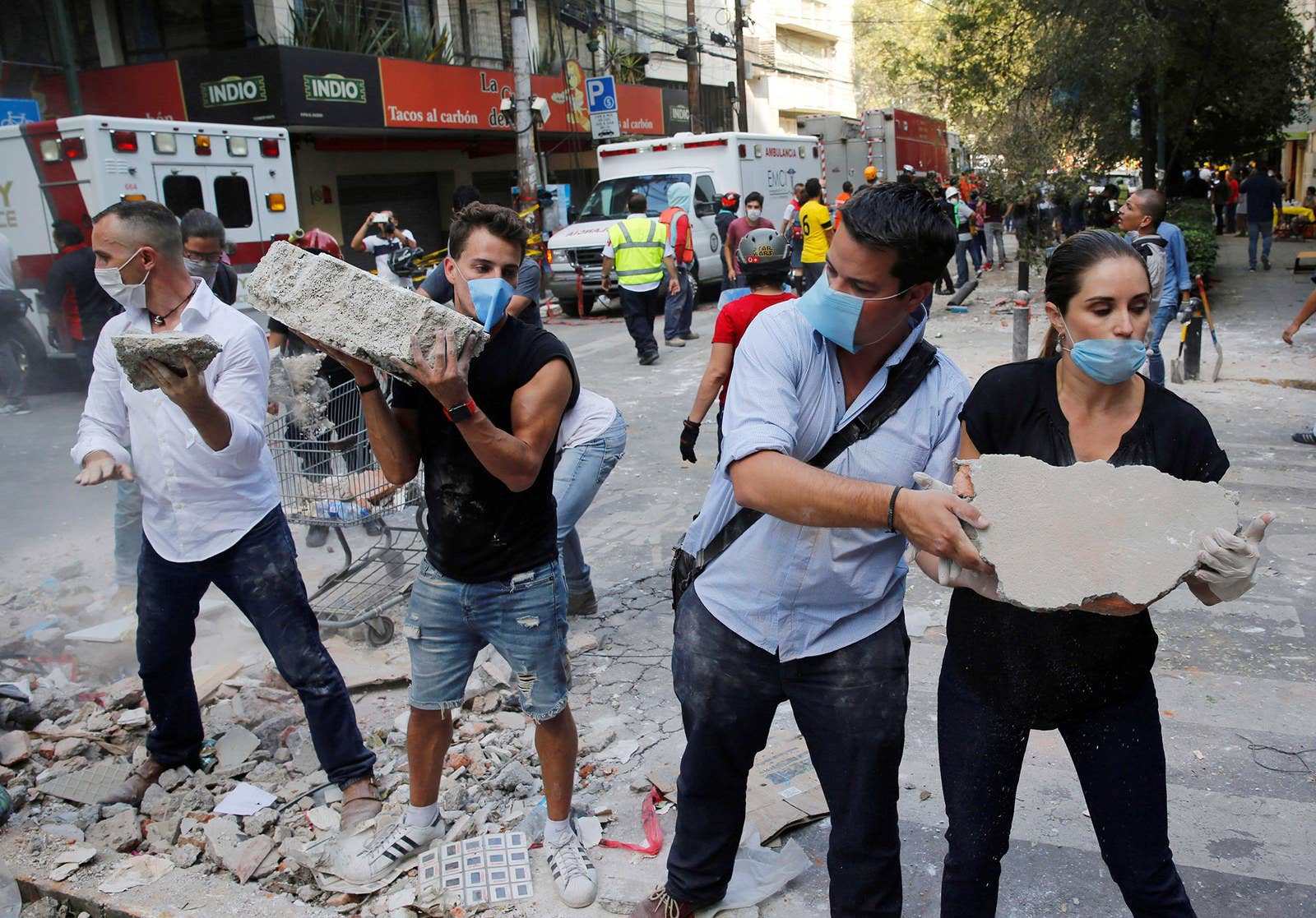 People remove debris outside a collapsed building in Mexico City.