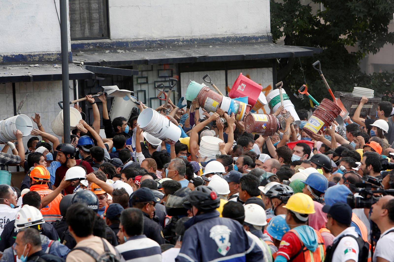 People pass buckets and shovels to remove the rubble of a collapsed building in Mexico City.