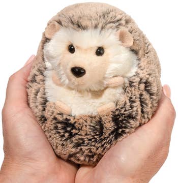Model holding a small stuffed hedgehog