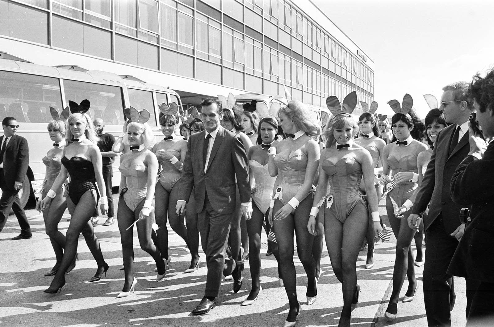 Hefner arrives with an entourage of Bunnies at London Heathrow Airport on June 25, 1966. During this trip to Britain, he opened his 16th Playboy Club, located in Park Lane, London.