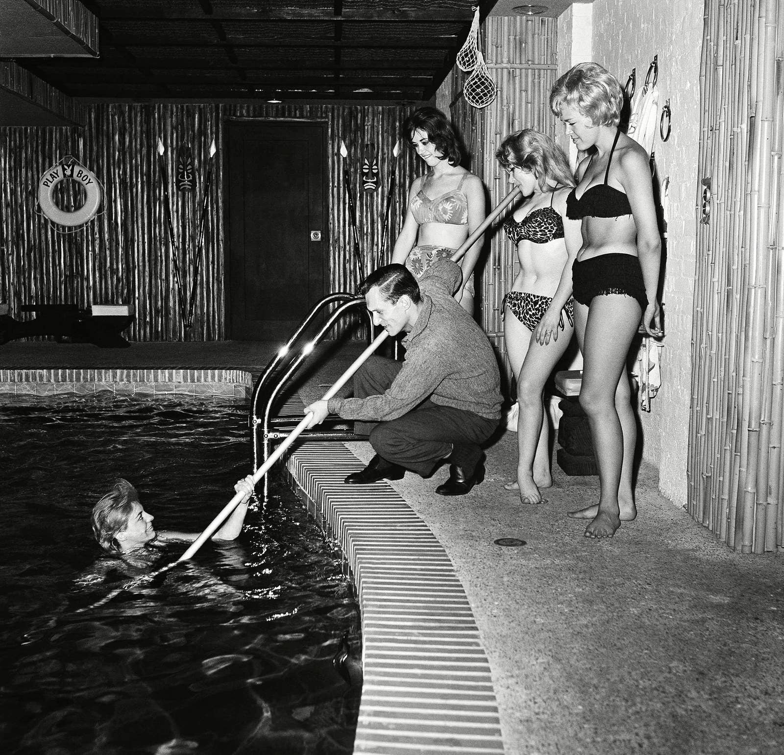 Hugh Hefner "rescata" a una nadadora en una de las albercas interiores de su departamento en Chicago, en 1961.