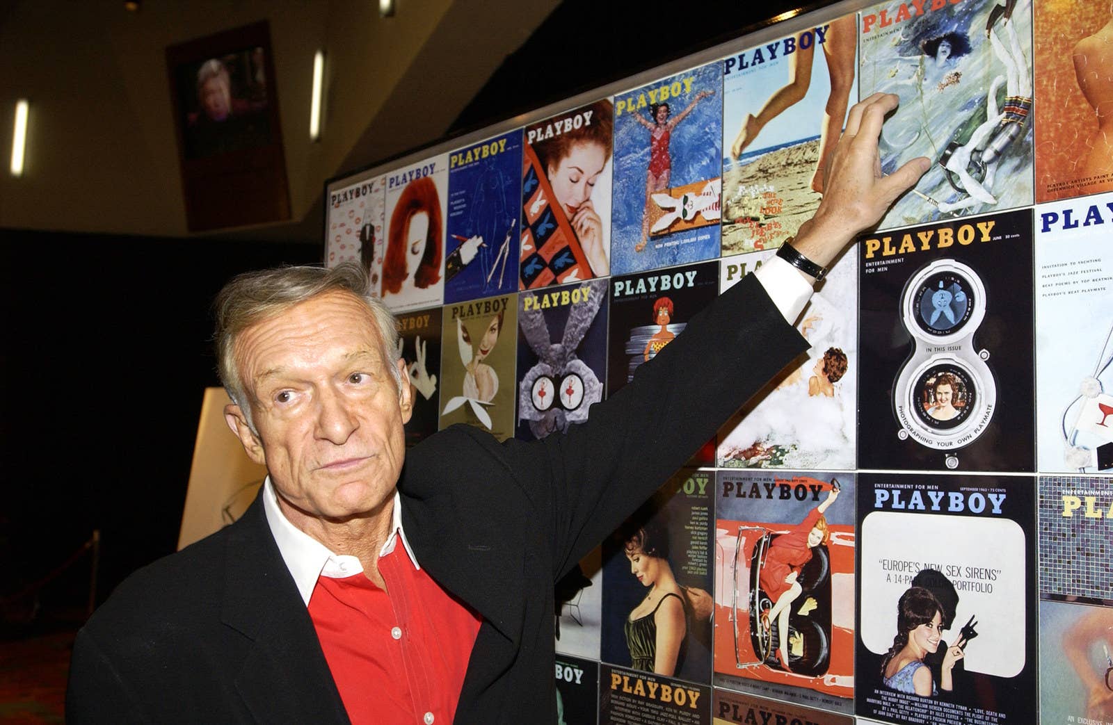 Hefner ve las portadas viejas de Playboy en la fiesta de aniversario #50 de la revista Playboy.