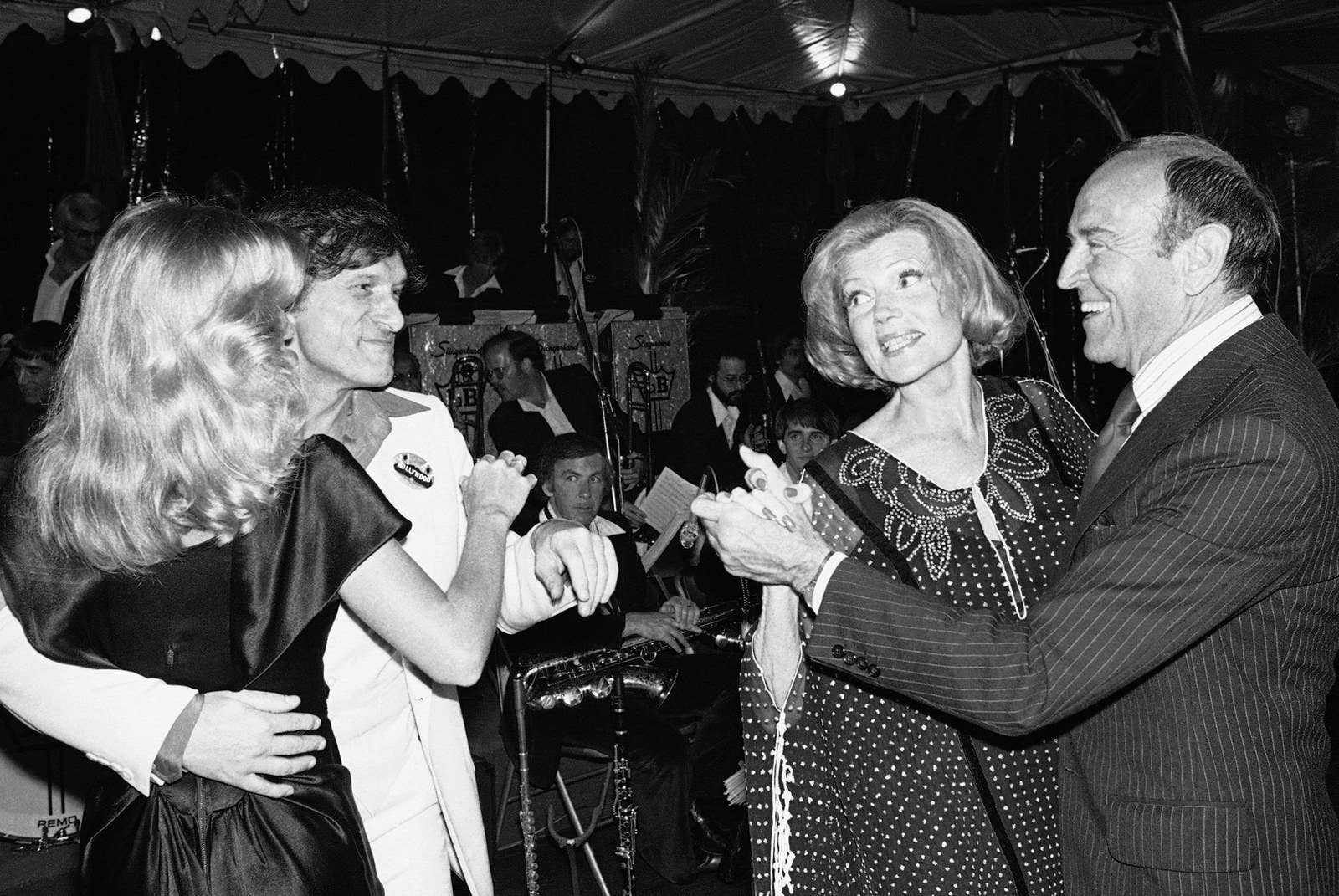 Hefner baila con la playmate Sandre Theodore, junto con la actriz Rita Hayworth y su coreógrafo, Hermes Pan, durante una fiesta de recaudación de fondos para salvar el letrero de "Hollywood" en 1978.
