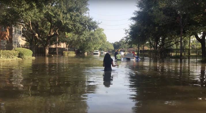 LaTanya Stewart wades through a flooded road to her apartment for the first time since the storm hit.