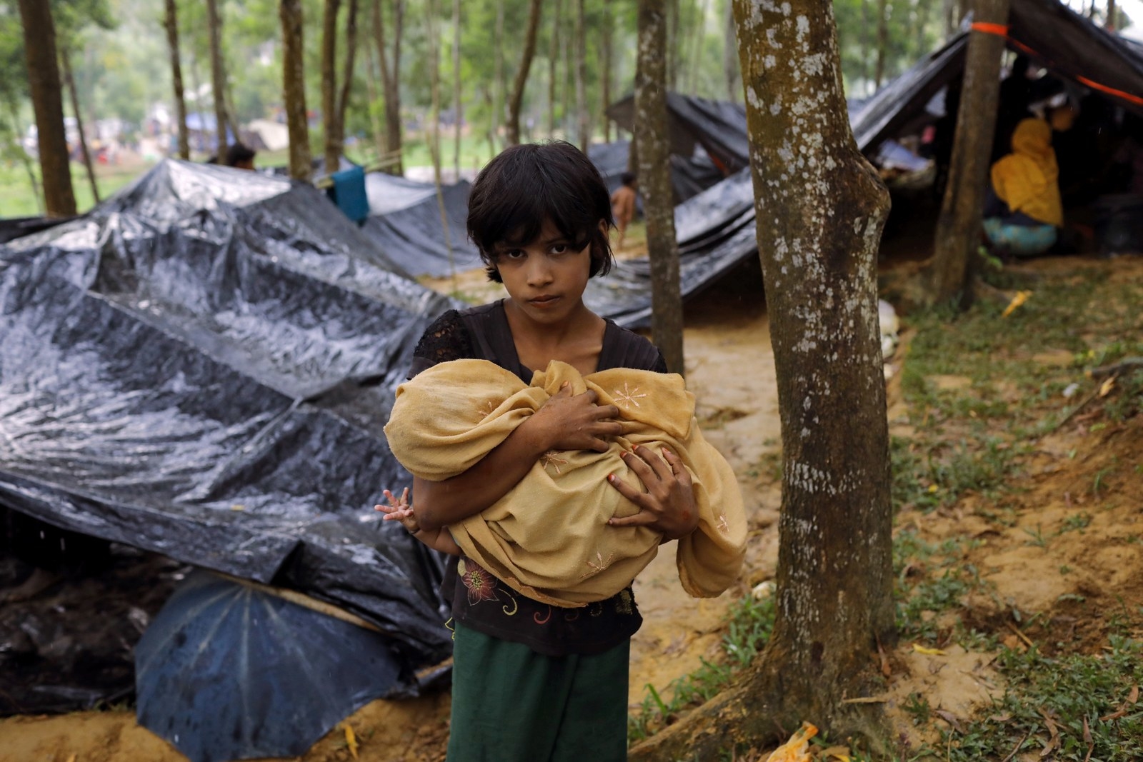 A Rohingya refugee from Myanmar's Rakhine state holds a baby at a camp in Bangladesh.