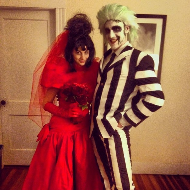 One person in a red wedding dress and one person in a black and white striped suit