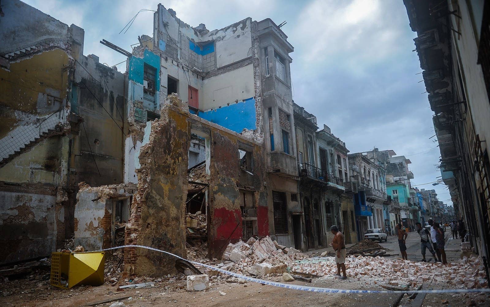 Cubans survey a collapsed building in Havana.