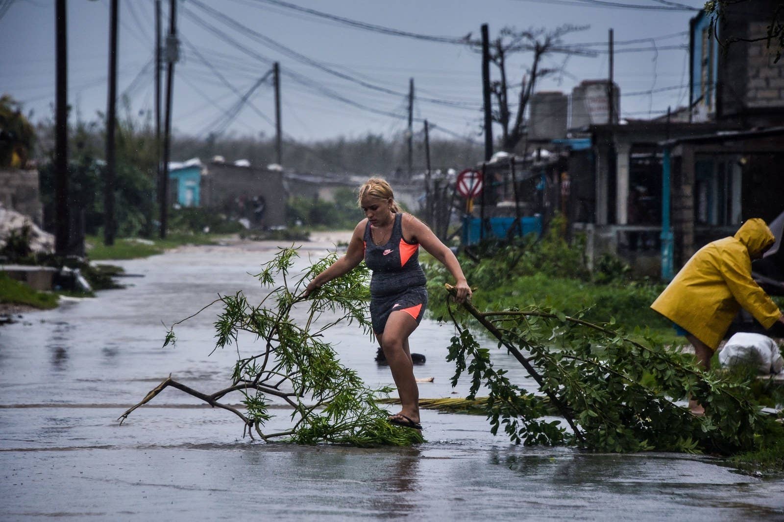 A woman clears downed branches following the storm.