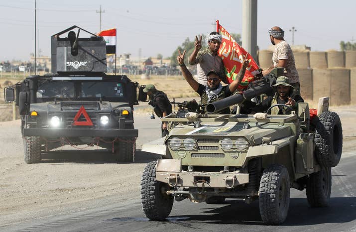 Iraqi forces flash the victory sign as they advanced toward Kirkuk's center.