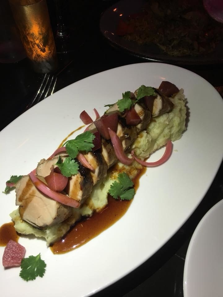 Over a bed of puré de batata (mashed potato) are slices of marinated and glazed pork tenderloin with plum and onion escabeche. The lean pork tenderloin pairs well with the buttery, creamy potato and pickled onion & plum.