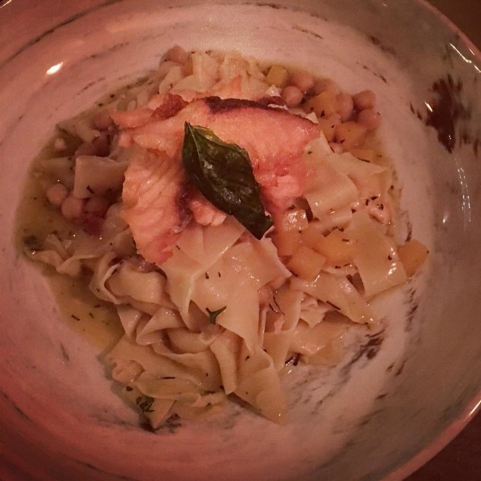 Pappardelle pasta with chickpeas and diced pumpkin is prepared in sweet pumpkin sauce with thyme. The pasta is topped with crispy salmon.
