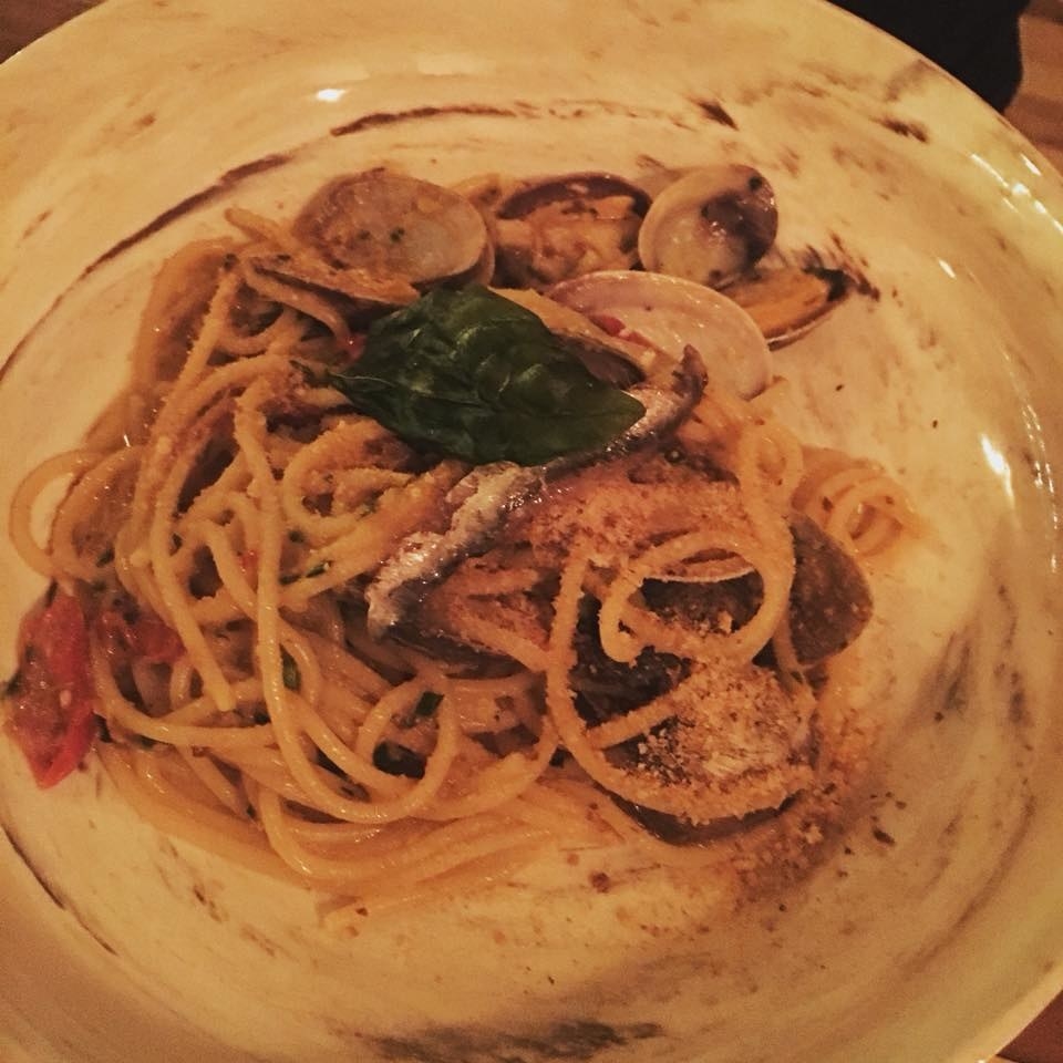 One of the signature dishes, the spaghetti is prepared with clams, anchovies, and tomato confit in olive oil sauce and topped with breadcrumbs.