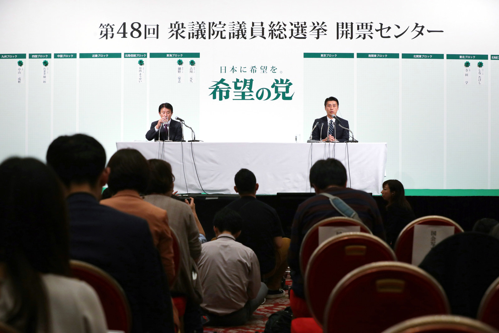 写真は記者が入れなかった会見場の様子。樽床伸二代表代行(壇上左)と細野豪志元環境相(同右)。