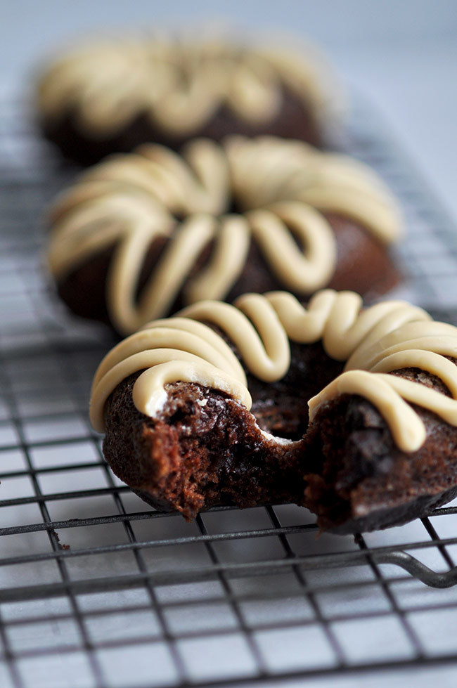Made-healthy donuts featuring everyone's favorite vegetable to hide—zucchini! Chocolate and maple syrup to help things taste extra yummy.