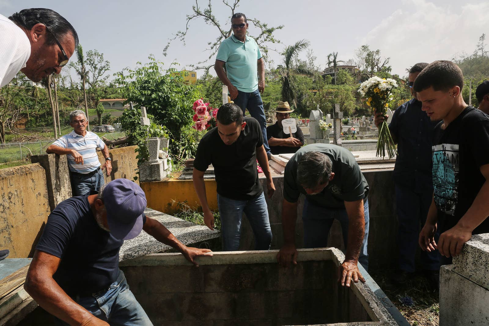 Mourners and cemetery workers gather at the gravesite on Oct. 19 in Utuado, Puerto Rico.