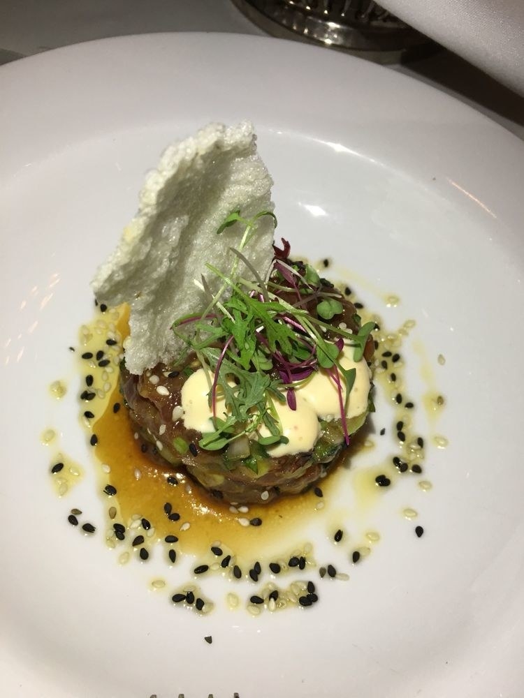 Chunks of sushi-grade, raw tuna is mixed in with creamy avocado and crunchy cucumber in rich soy sauce, and then topped with dollop of sriracha aioli and micro greens in this melange many flavors and textures. Try the tuna poke with puffed rice cracker.