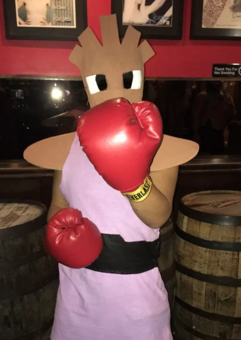 A person wearing boxing gloves and a mask of Pokemon character