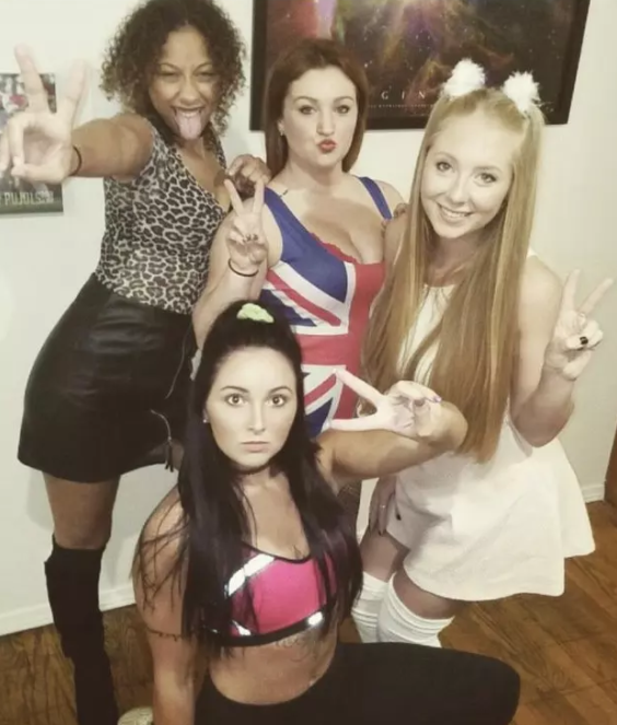 Four women in outfits including an animal-print tank top and miniskirt and a Union Jack dress