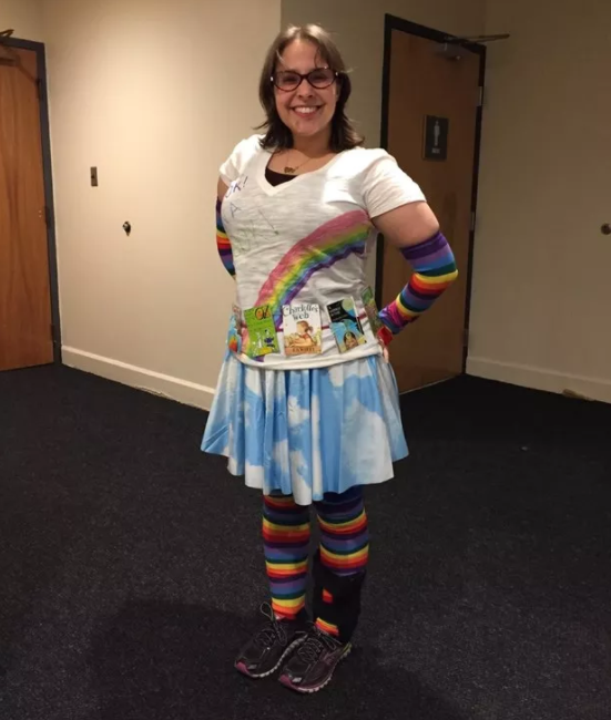 A woman wearing a rainbow T-shirt, long gloves, and tights with a short skirt