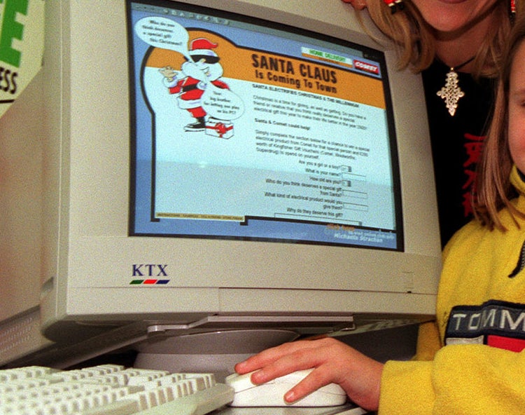 A mother and daughter using an old computer that says &quot;Santa Claus is coming to town&quot;