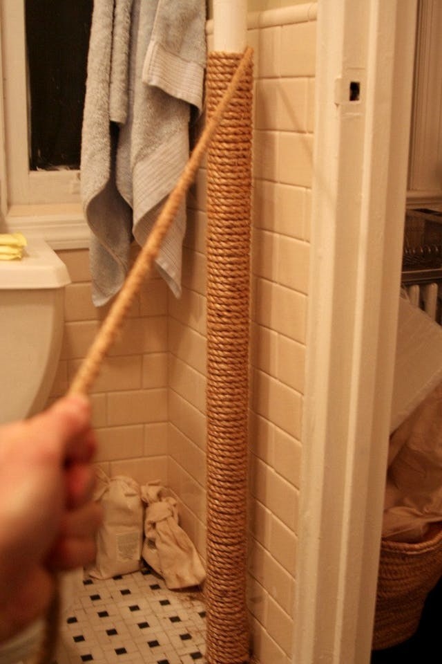 person wrapping sisal rope around their radiator pipe