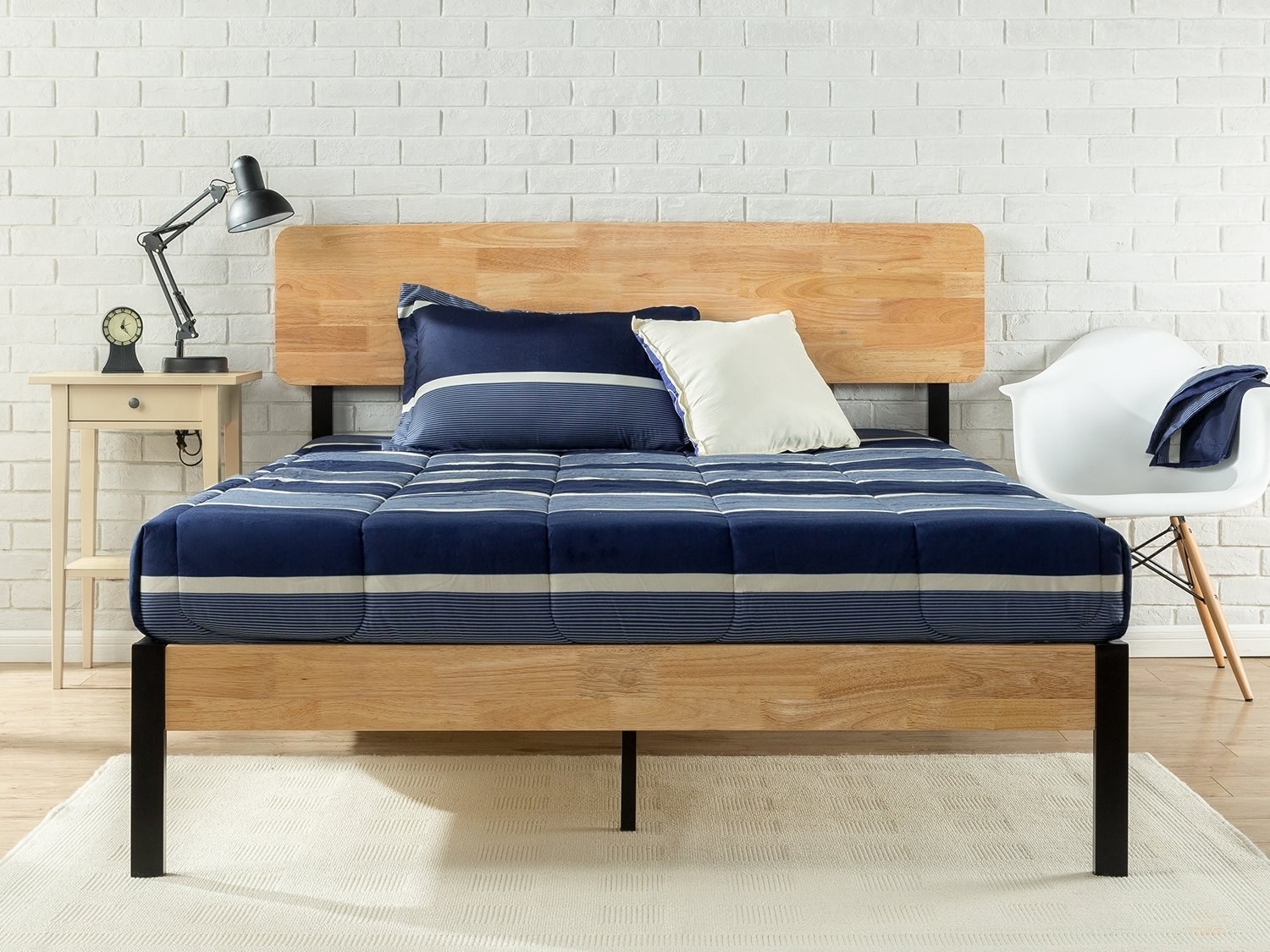 wooden bed frame with navy blue bedding