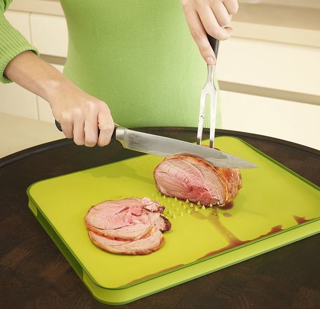 A multi-function chopping board with a meat grip on one side and an angled cutting surface designed to catch any juices or crumbs.