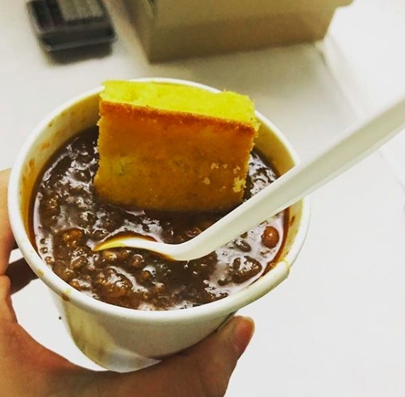 A hearty cup of chili with ground beef and various beans was complemented by a piece of cornbread.